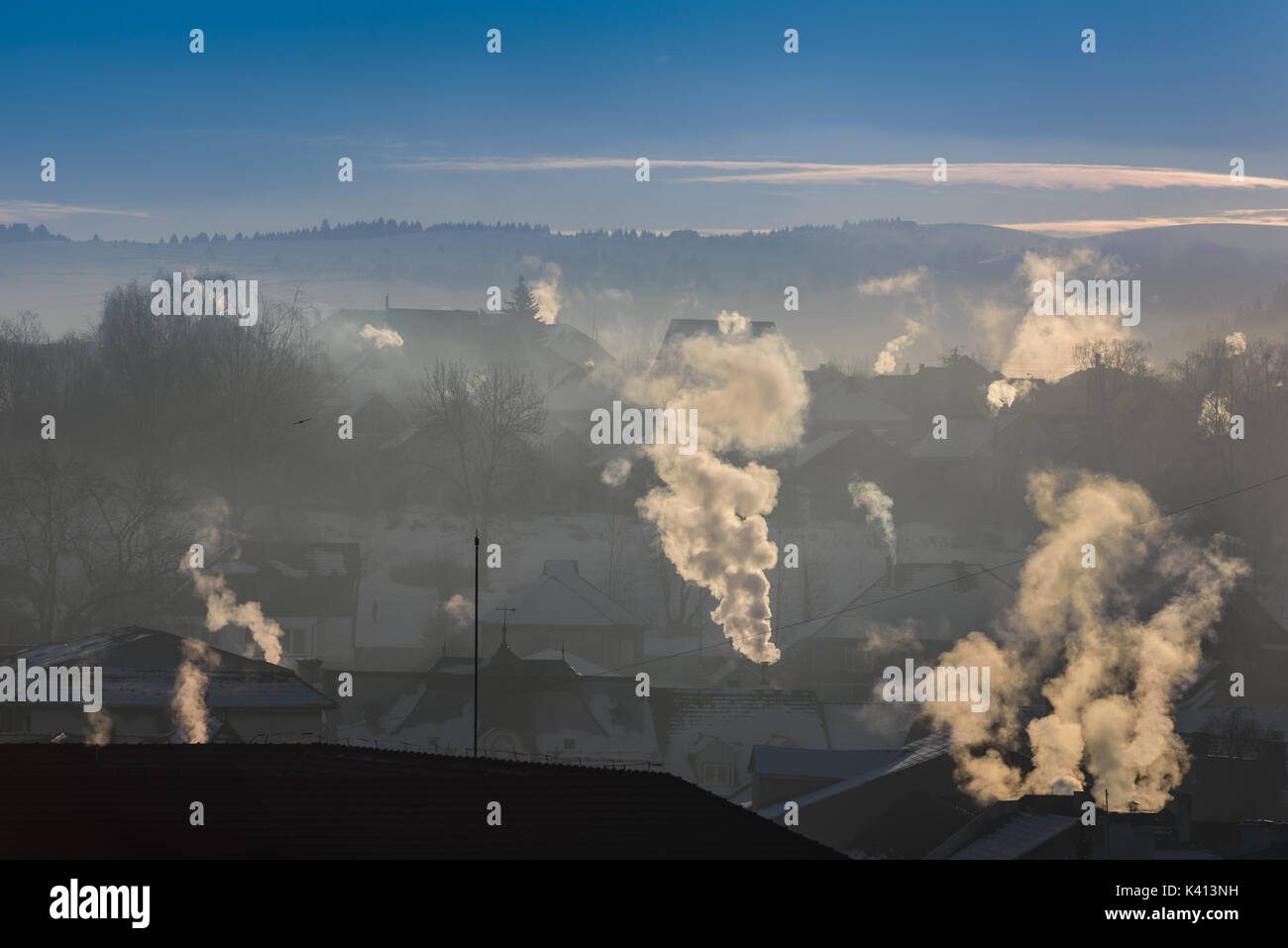 È molto freddo al mattino sunrise in città, comignoli fumanti. Inquinamento ambientale. Foto Stock