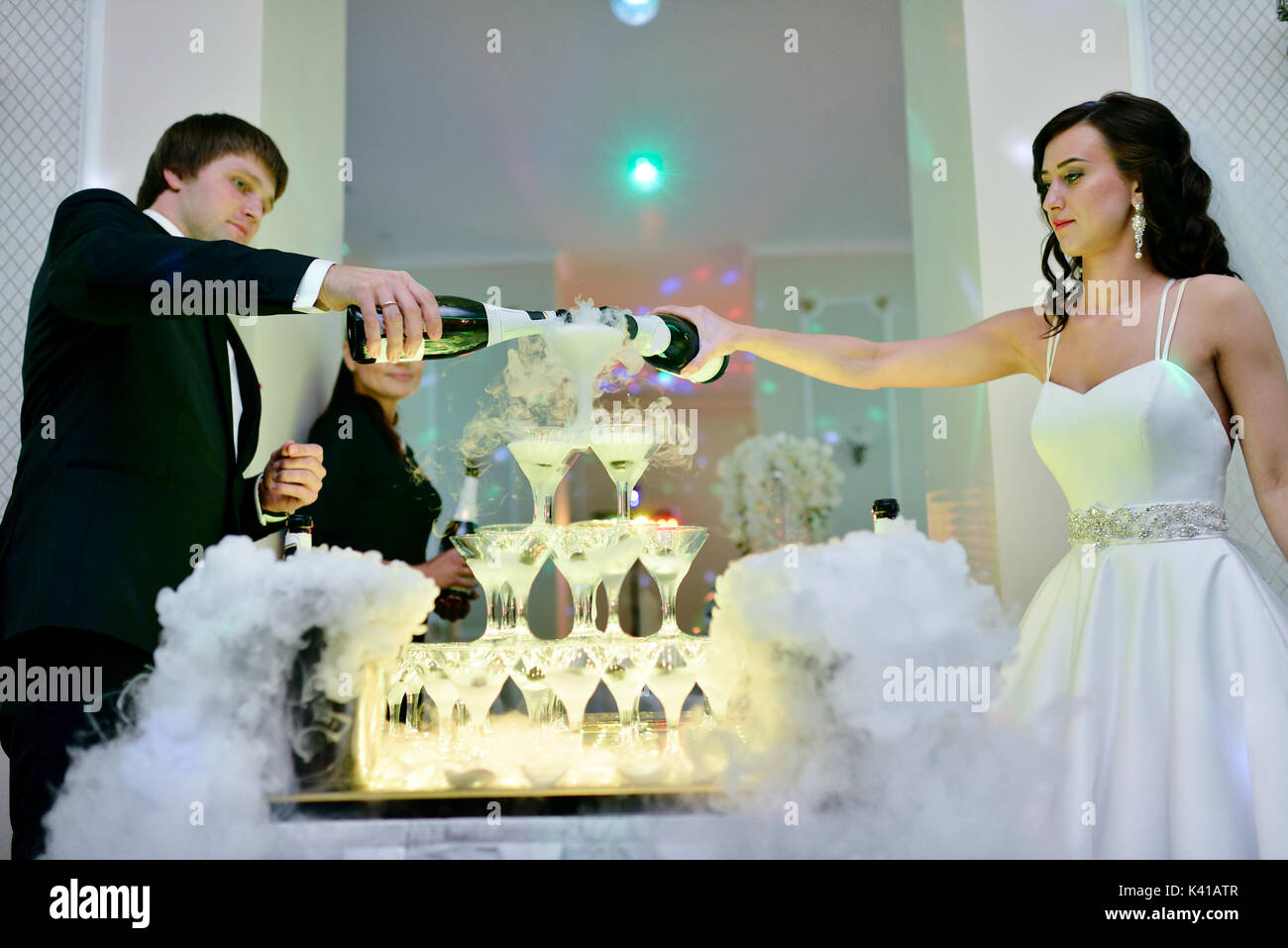 Bella coppia di nozze è versando champagne in ambienti interni Foto Stock