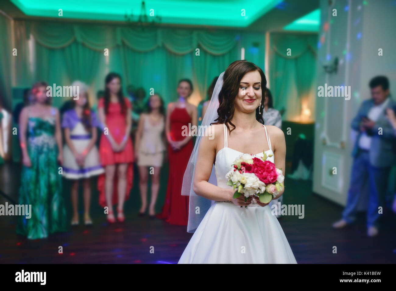 Bellezza sposa in abito nuziale con velo di pizzo sta gettando Bouquet nozze in ambienti interni Foto Stock