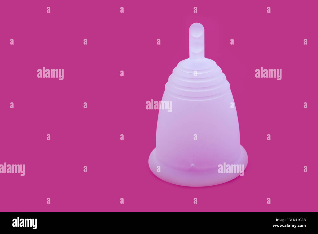 Close up di un silicone coppa mestruale con un sfondo rosa Foto Stock