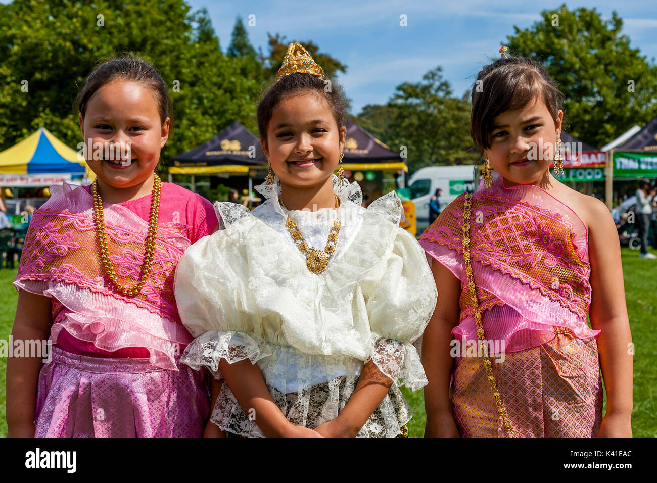 Tre bambini Anglo-Thai vestite nel tradizionale costume tailandese, Brighton festival Tailandese, Brighton, Sussex, Regno Unito Foto Stock