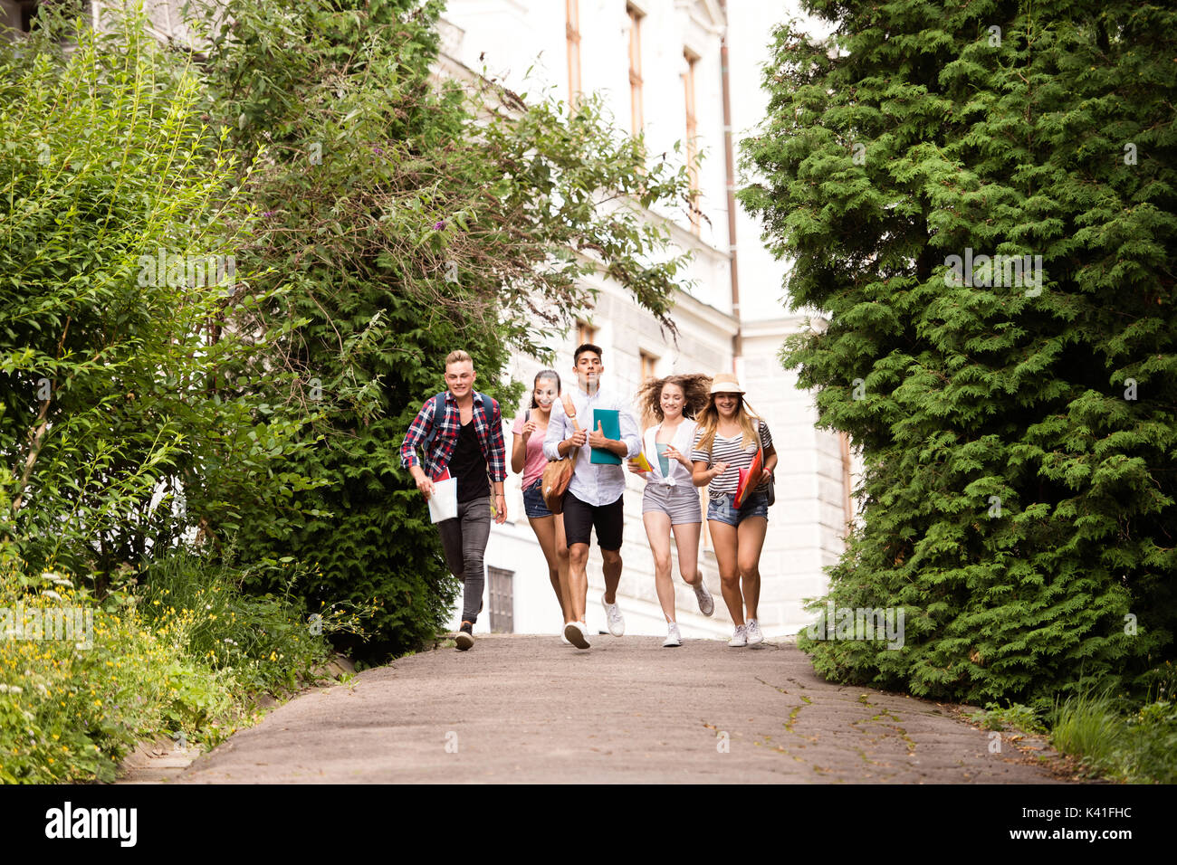 Gruppo di attraente studenti adolescenti in esecuzione dalle università. Foto Stock