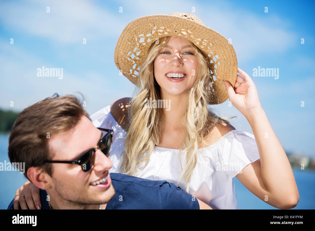 Una foto di una giovane e bella donna di essere trasportato sul suo fidanzato della schiena e ridere felicemente. Foto Stock