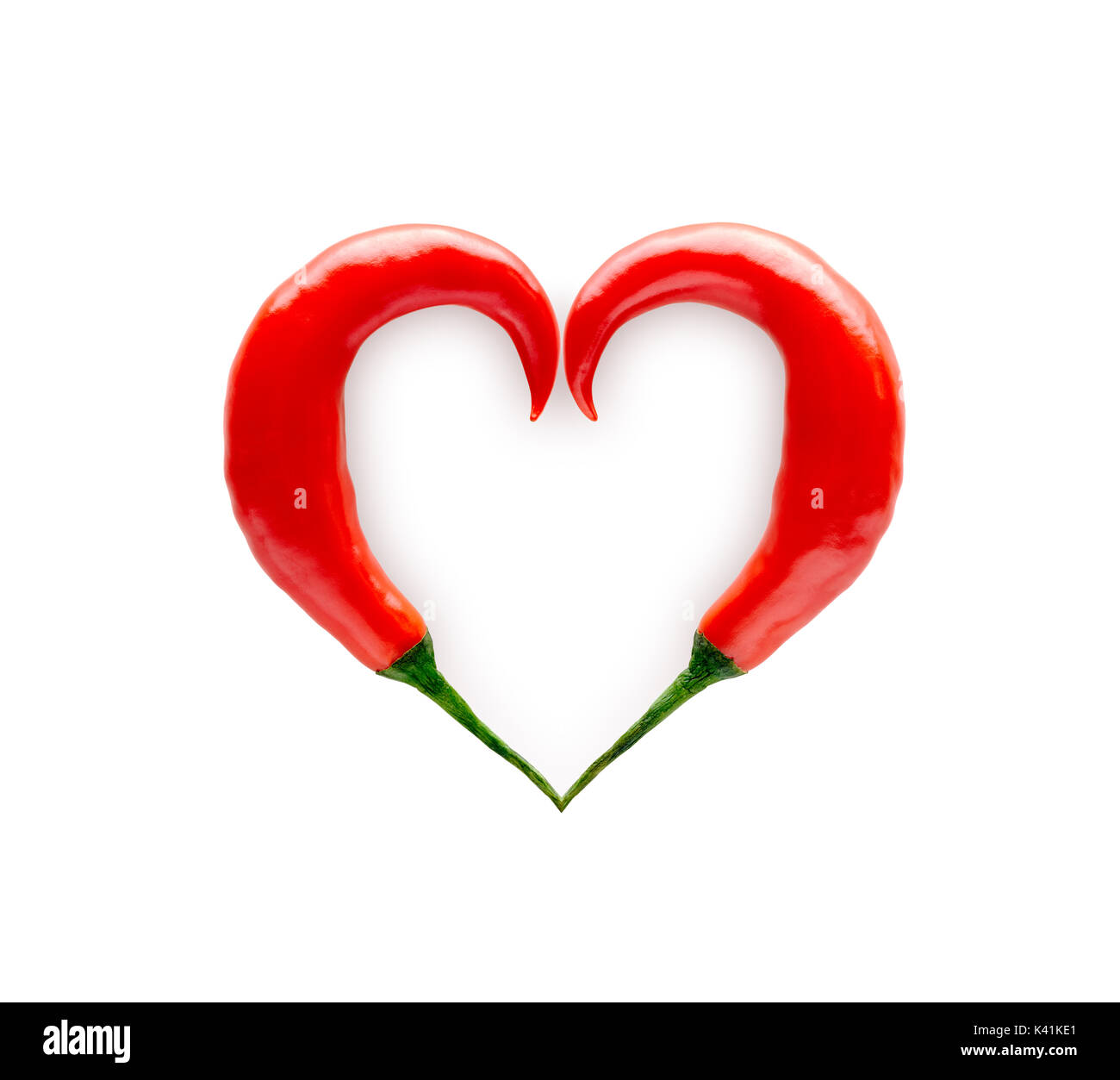 Chili Peppers formando una forma di cuore isolato su sfondo bianco Foto Stock