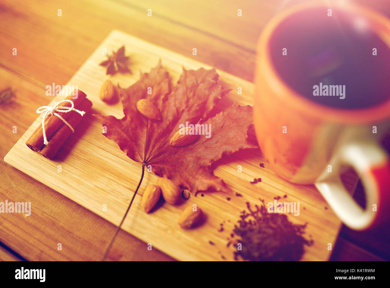 Tazza di tè, maple leaf e mandorla sul pannello di legno Foto Stock