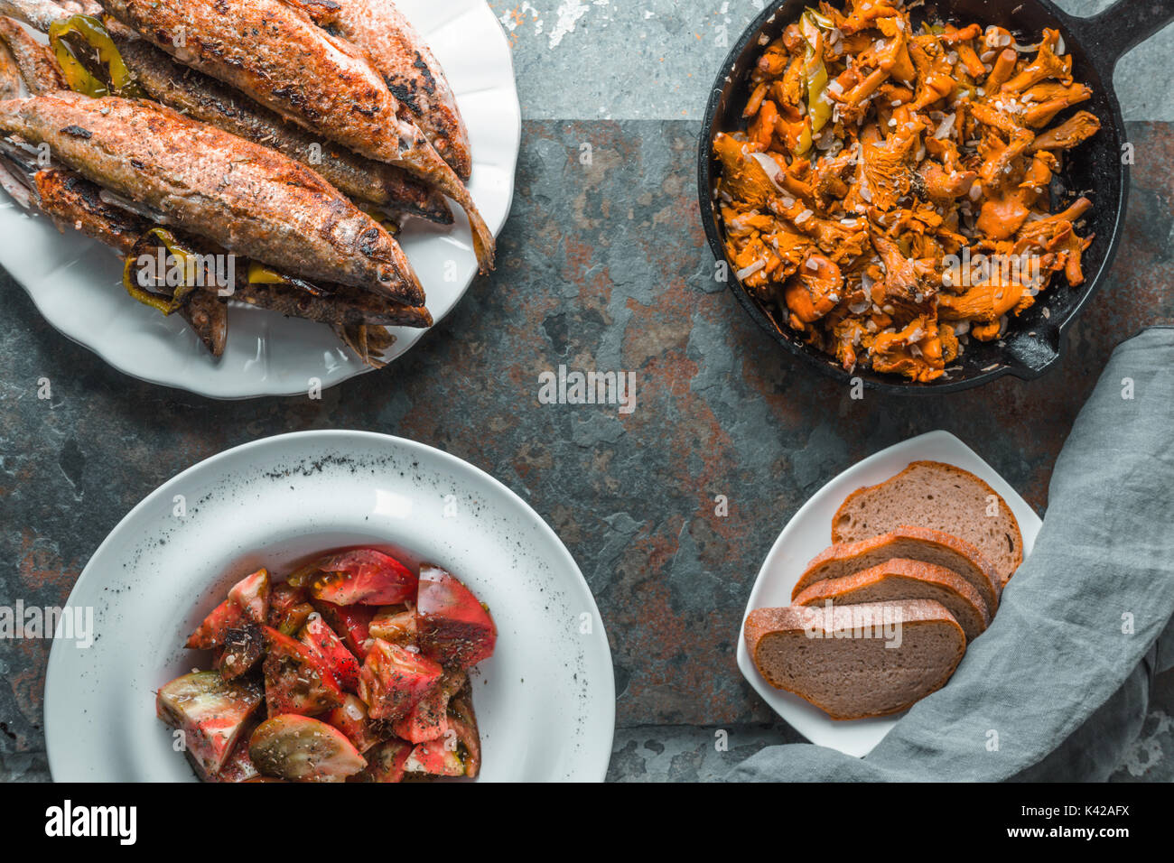 Finferli fritte, pesce su una piastra, i pomodori e il pane di spazio libero in orizzontale Foto Stock