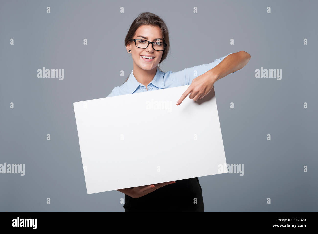 Bella imprenditrice che mostra sulla lavagna vuota Foto Stock