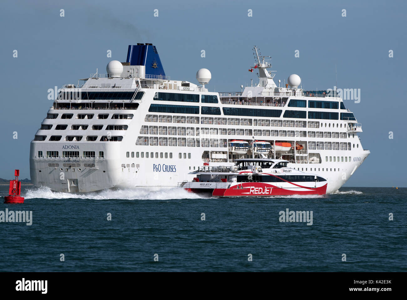 Acqua di Southampton Inghilterra UK Agosto 2017. La nave di crociera Adonia voce fuori in mare e Jet rosso 6 passando il Black Jack Bouy voce a Cowes sull'ISL Foto Stock
