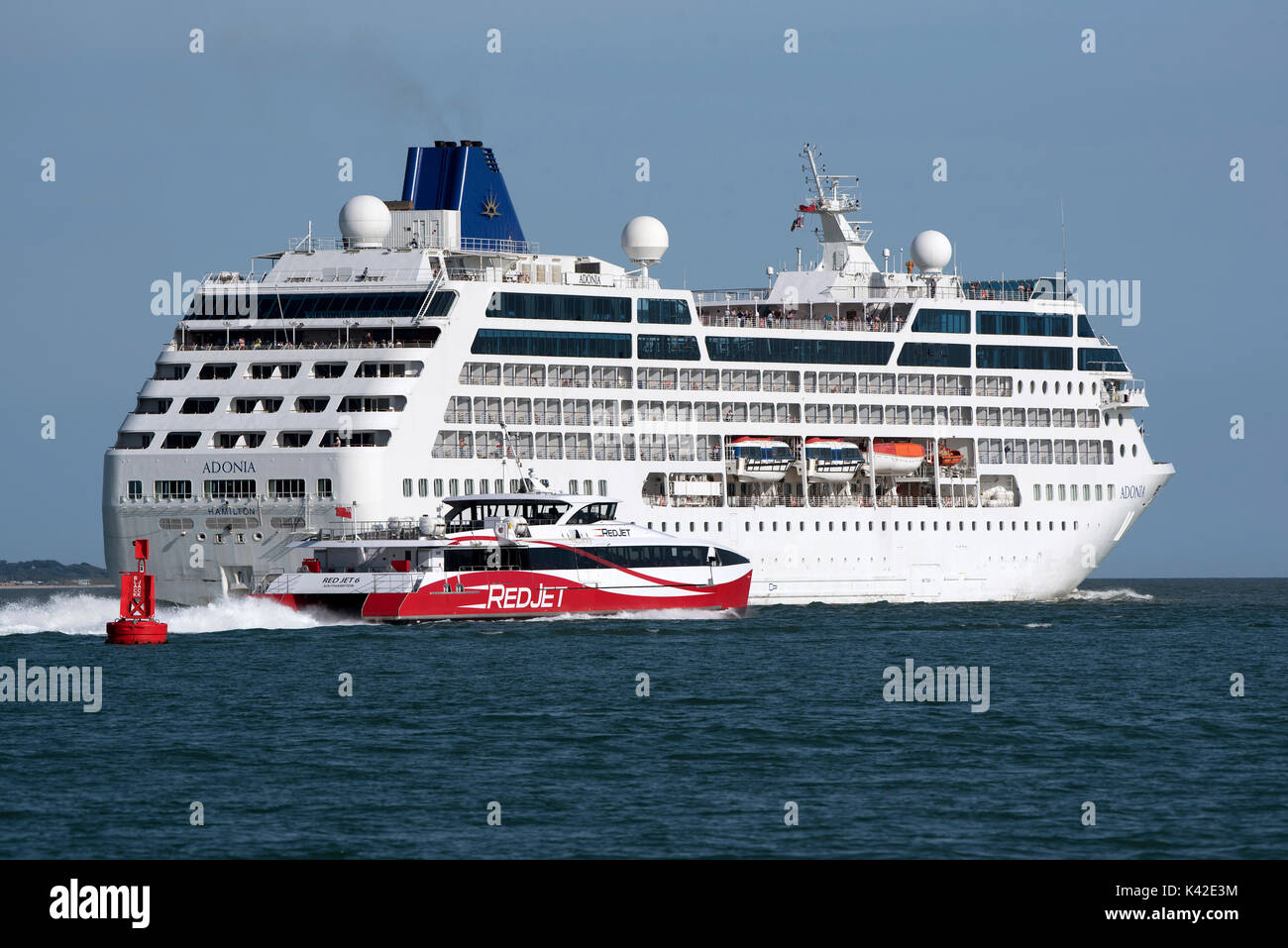 Acqua di Southampton Inghilterra UK Agosto 2017. La nave di crociera Adonia voce fuori in mare e Jet rosso 6 passando il Black Jack Bouy voce a Cowes sull'ISL Foto Stock