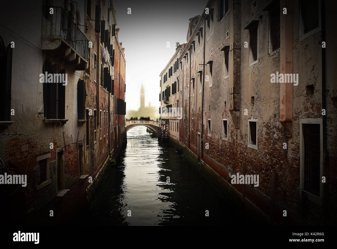 Un tipico canale veneziano, con architettura veneziana su entrambi i lati che riflette nel canale dell'acqua. Venezia, Italia Foto Stock