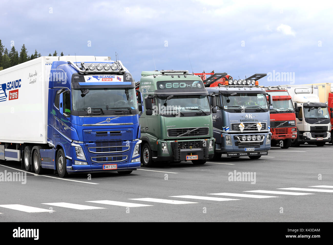 FORSSA, Finlandia - 25 agosto 2017: Colorful Volvo Trucks parcheggiato sul cantiere di asfalto di un arresto carrello in un giorno nuvoloso. Foto Stock