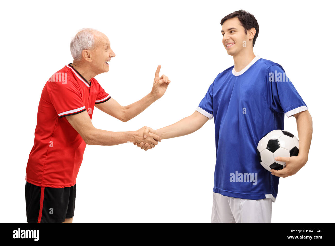 Vecchio giocatore di calcio si stringono la mano con un giovane giocatore e consigliandolo isolati su sfondo bianco Foto Stock