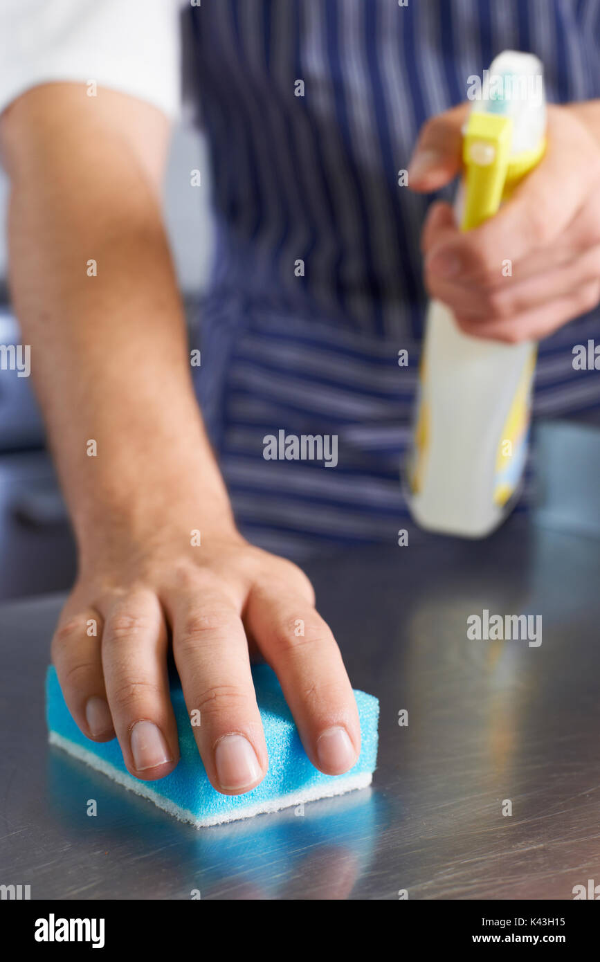 Chiusura del lavoratore nel ristorante la pulizia della cucina verso il basso dopo il servizio Foto Stock