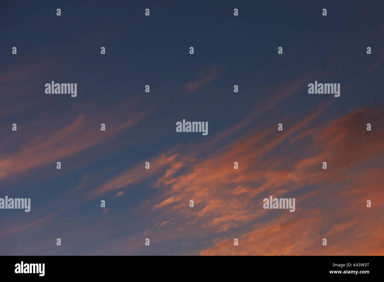 Arancione tramonto nuvole sul cielo blu. Drammatico tramonto tramonto sullo sfondo del cielo Foto Stock