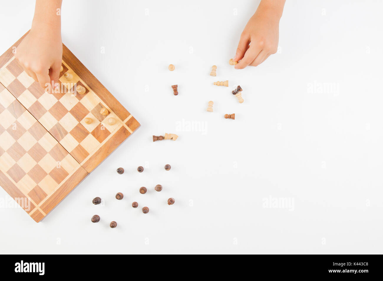 Vista superiore della mano di capretto e la scacchiera con pezzi di scacchi Foto Stock