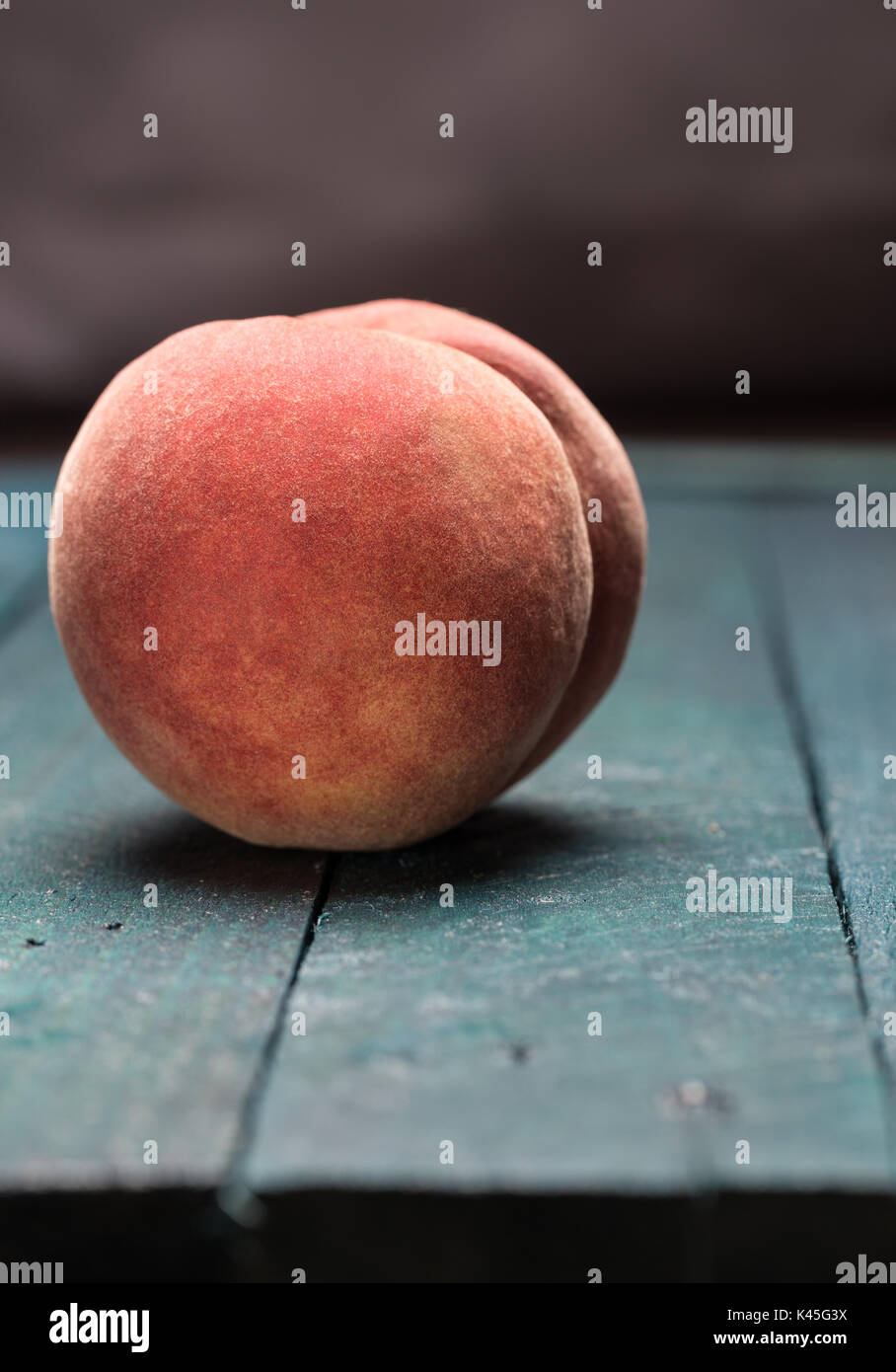 Peach sulla benzina di legno colorato sfondo. Foto Stock