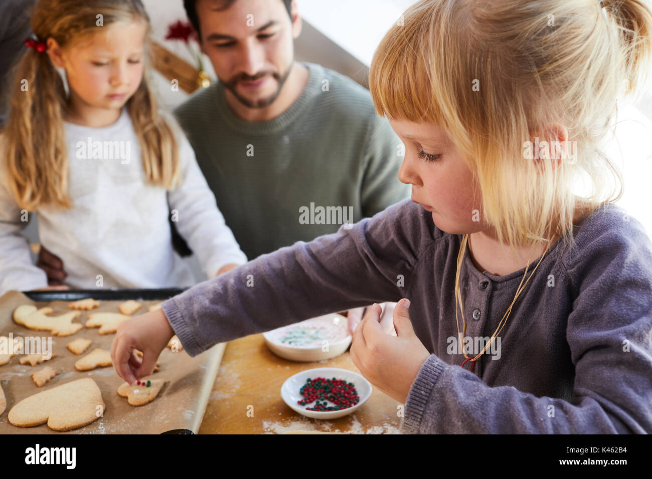 Famiglia la cottura biscotti di Natale, padre e le figlie, decorazione, dettaglio Foto Stock