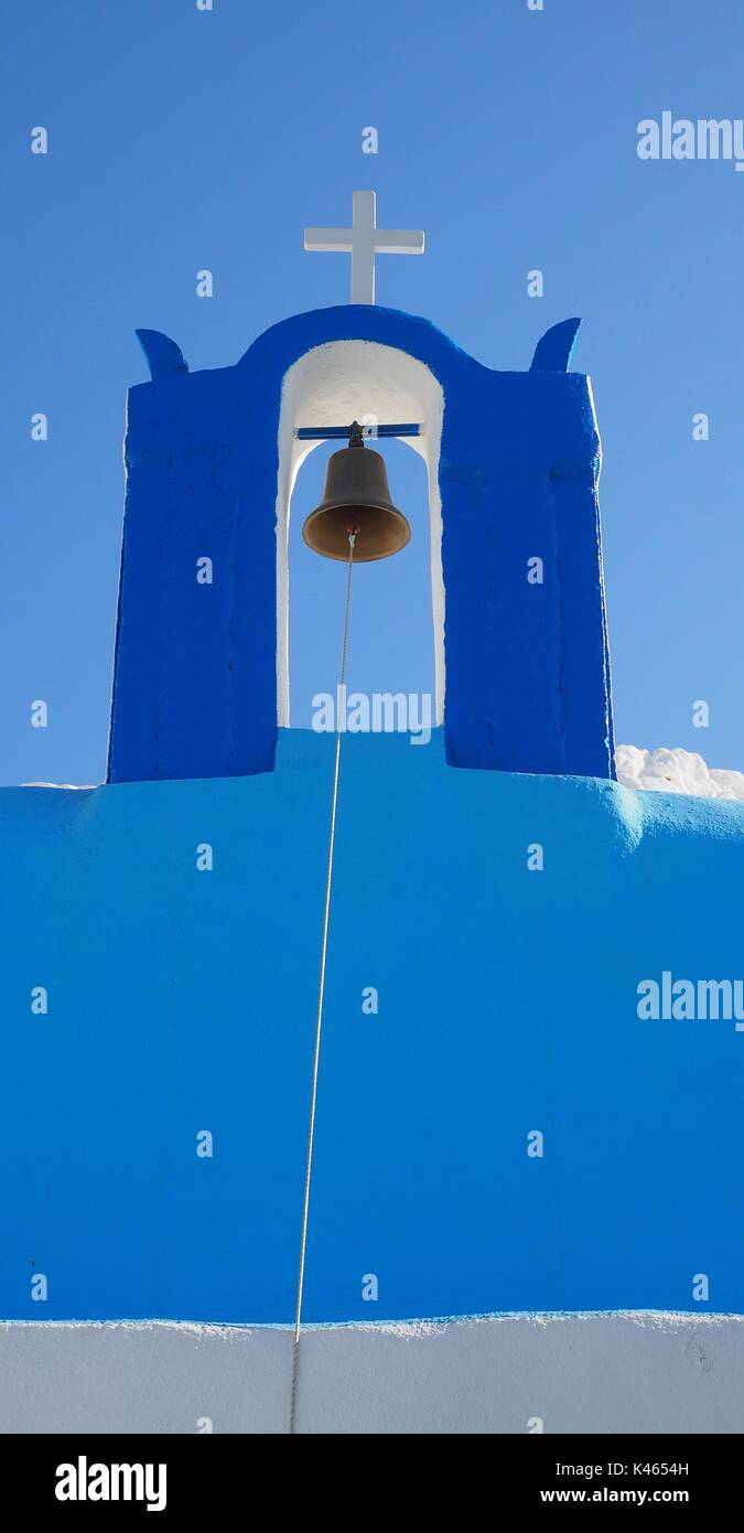 Tutti i blues di Oia - Santorini - chiesa blu sull'isola greca con la croce e la campana contro un cielo blu Foto Stock
