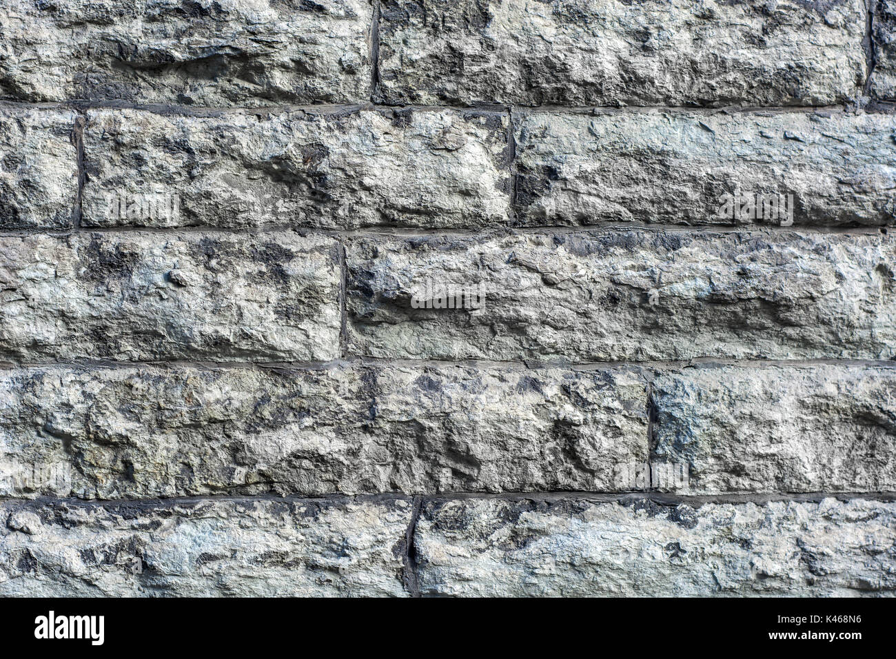 L'immagine di un frammento di parete in muratura di grezzo, grigio pietra grezza da utilizzare come sfondo. Foto Stock