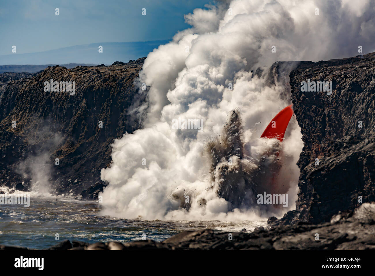 Antenna vista diurna di fuoco del tubo flessibile a forma di cascata flusso di lava dal vulcano in Hawaii esplodendo nell'oceano Foto Stock