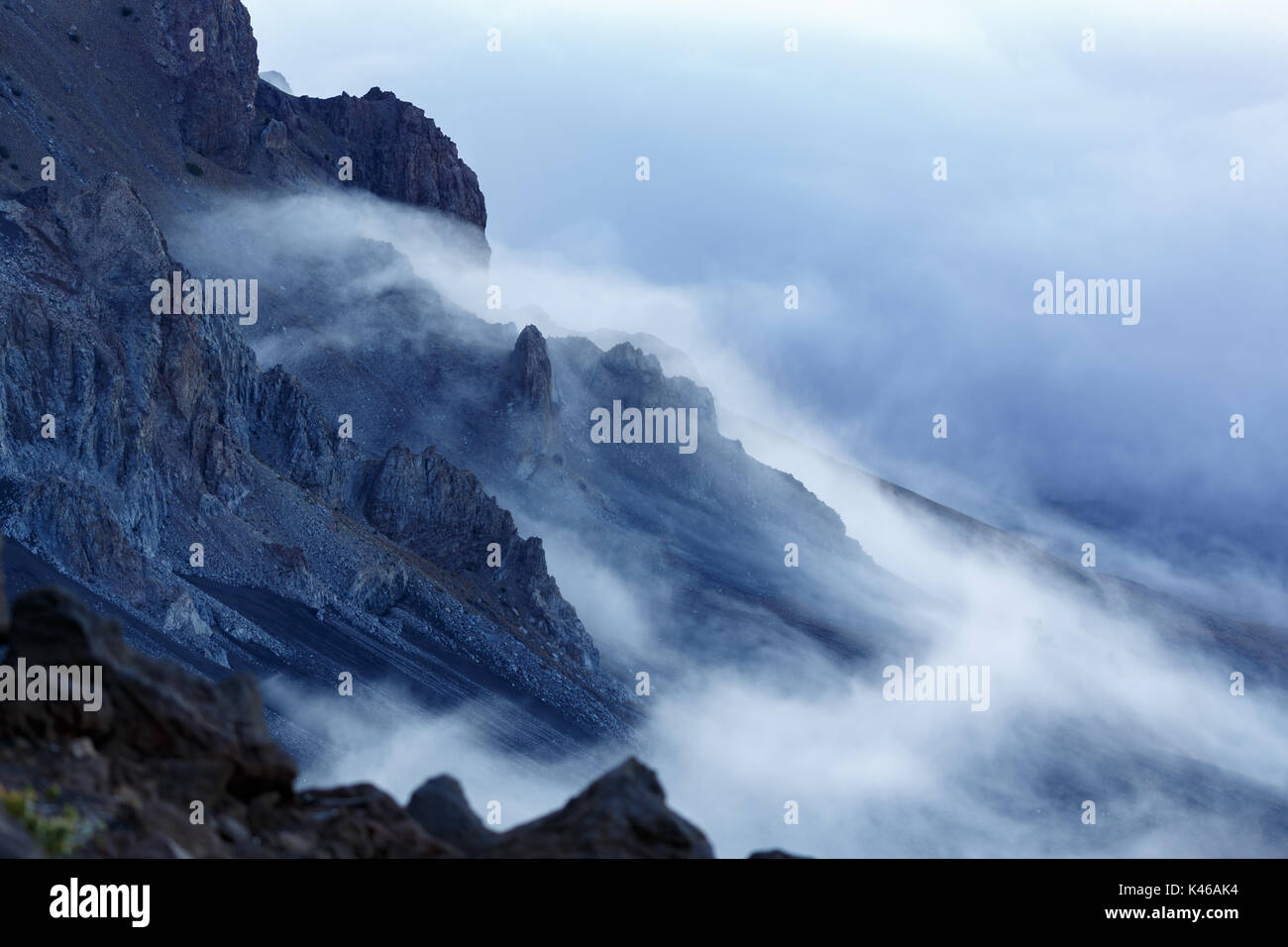 La nebbia copre i picchi minori dell'aspro paesaggio vulcanico Foto Stock