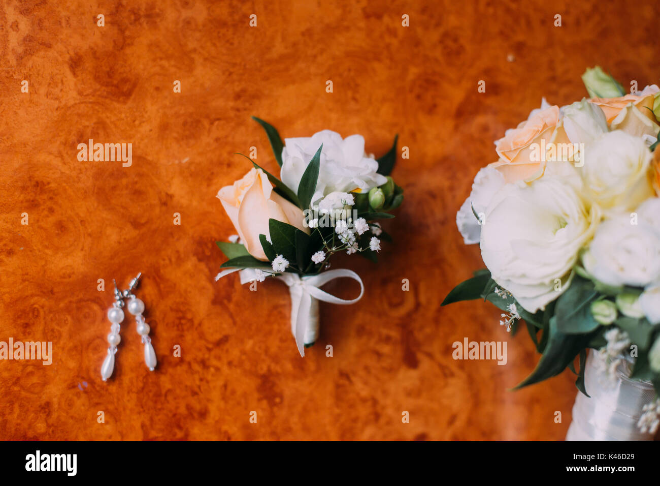 Sposa orecchini, boutonniere e bouquet nuziale sul rustico sfondo di legno Foto Stock