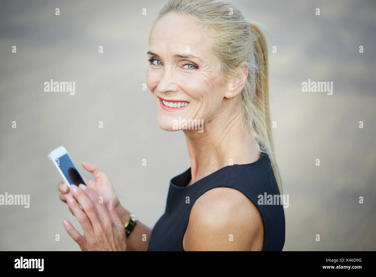 Close up ritratto di sorridere imprenditrice utilizzando il telefono cellulare. Foto Stock