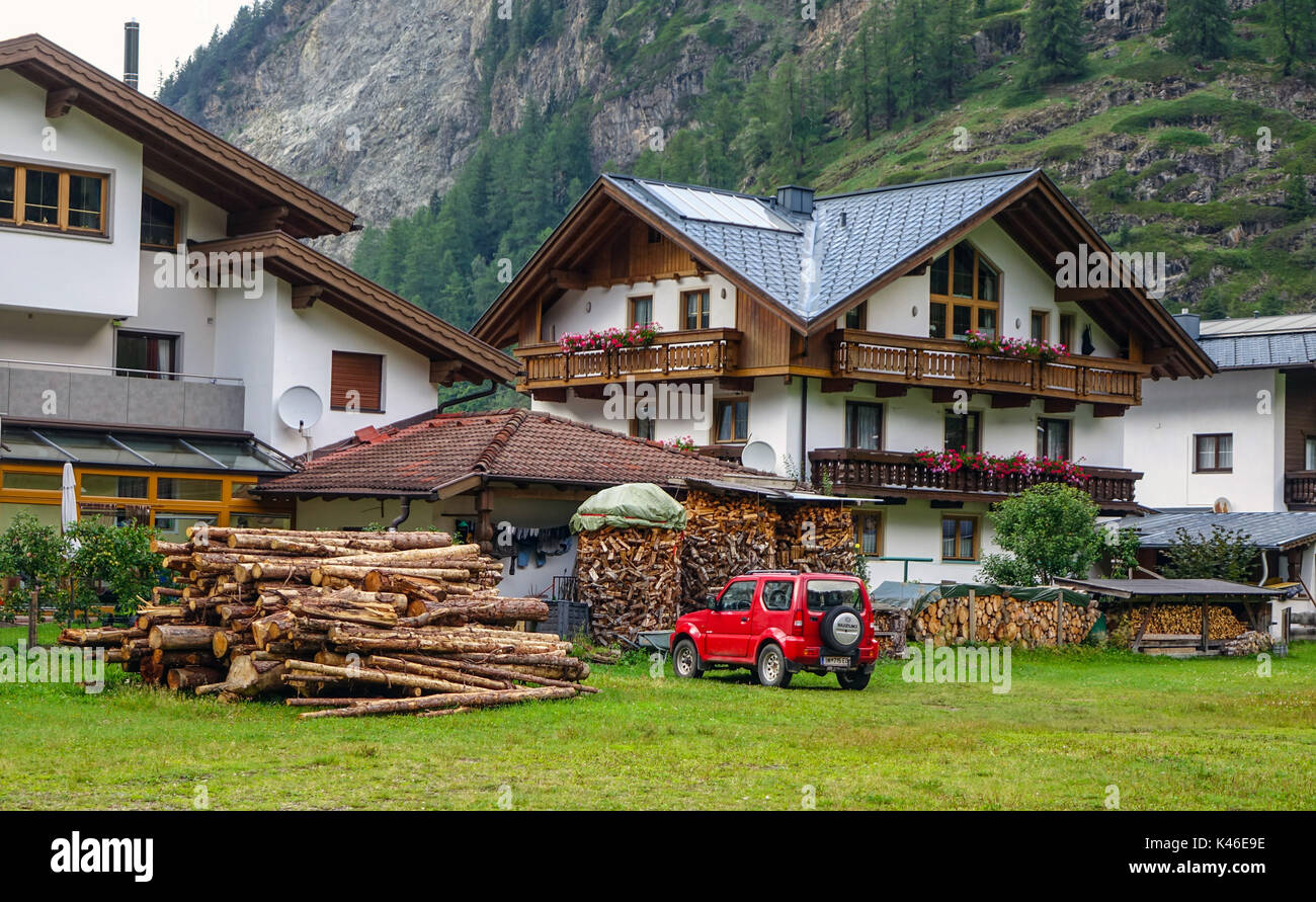 Grandi case con pile di ciocchi di legna per il riscaldamento invernale, Huben, Solden Austria Foto Stock