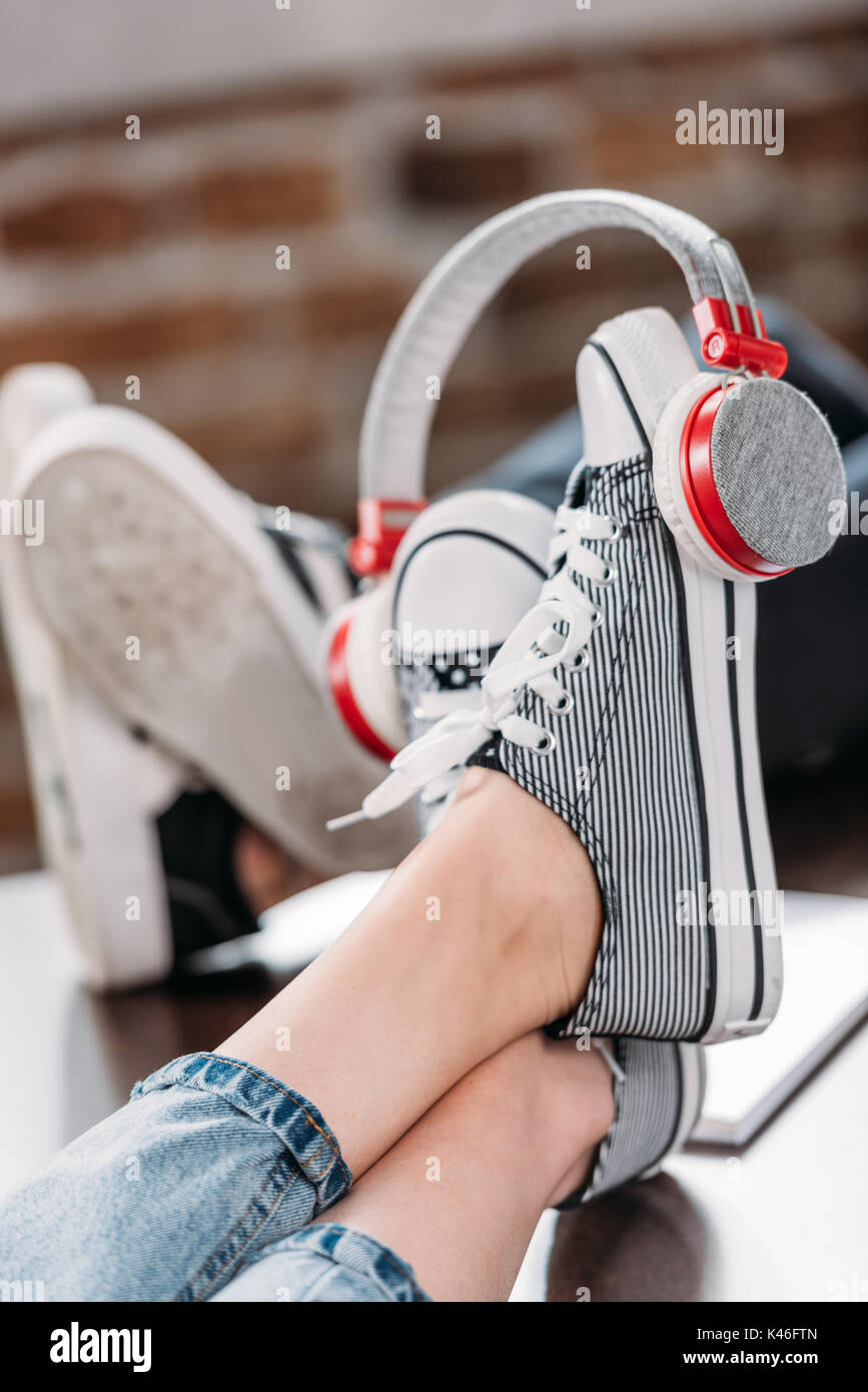 Vista ravvicinata di una donna in piedi in scarpe eleganti con le cuffie  sul tavolo di legno Foto stock - Alamy