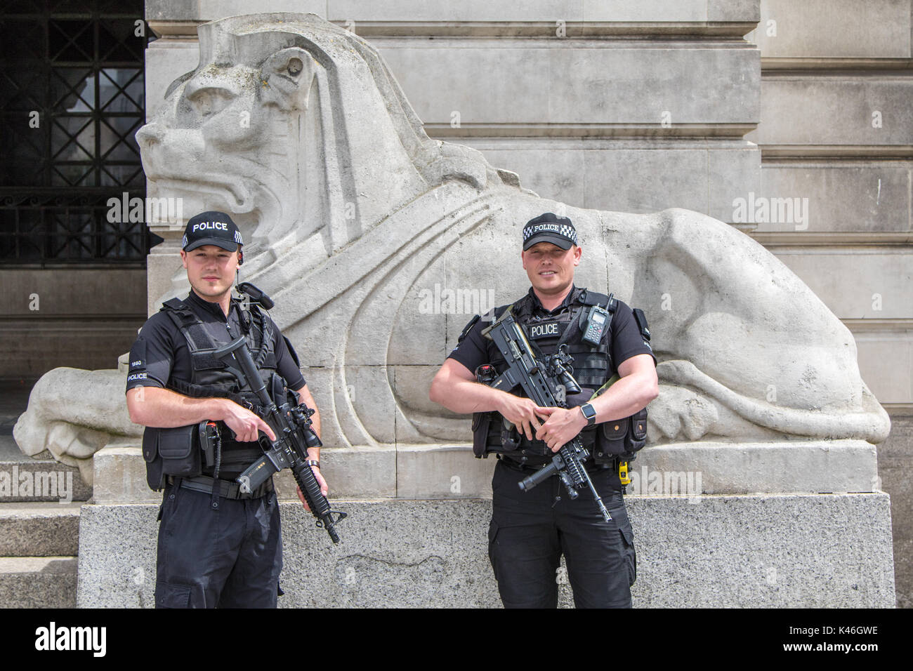 Due maschio poliziotti armati in piedi di fronte ad una statua di Lion al di fuori del Consiglio di Nottingham edificio in Piazza del Mercato Vecchio Foto Stock