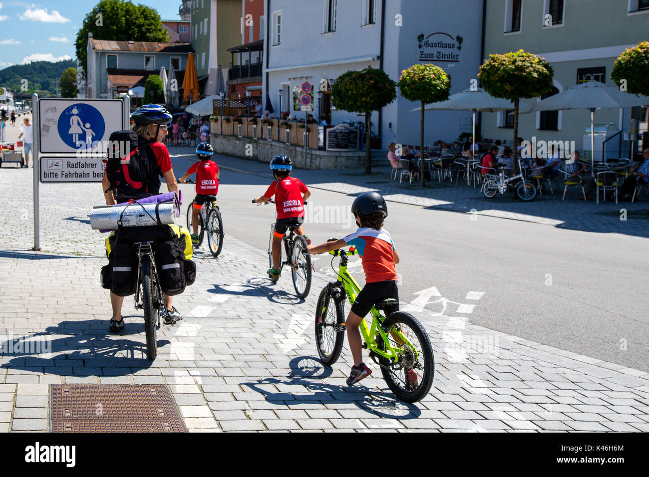 I bambini al di sotto del ciclo di istruzione in Passau, Baviera, Germania. Essi sembrano ignorare il 'No Ciclismo' ordine il segno. Foto Stock
