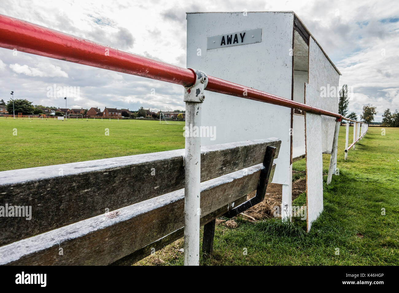 Radici di erba di calcio. Rifugio di base accanto al passo con poco sicuro di truciolato pannello posteriore per la squadra fuori. Langtoft United FC home terra, Inghilterra, Regno Unito. Foto Stock