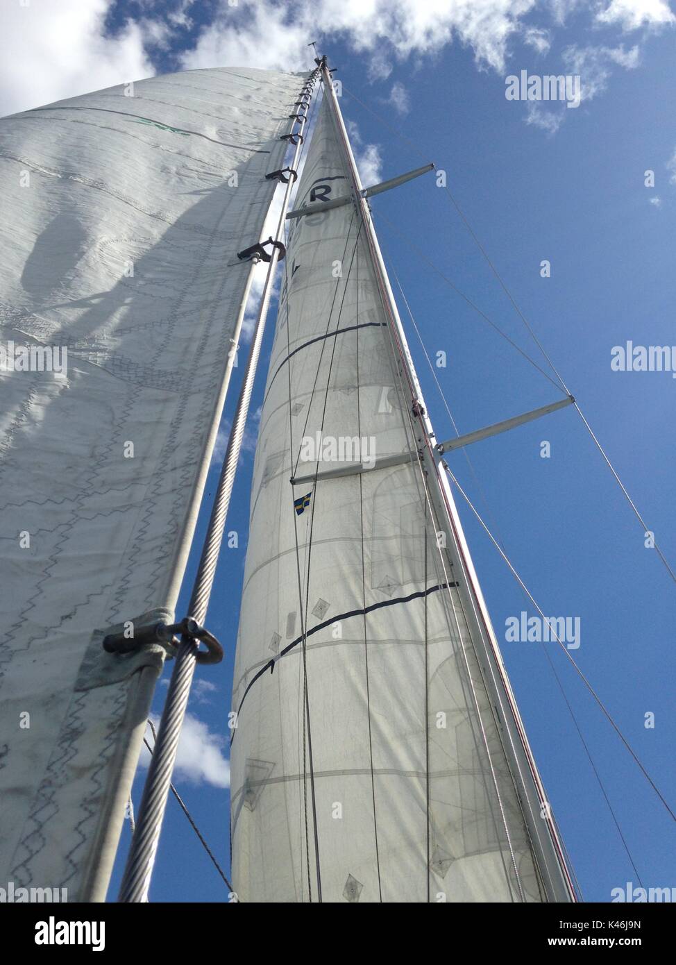 Barca a vela in una giornata di sole, vele bianche contro un cielo blu Foto Stock