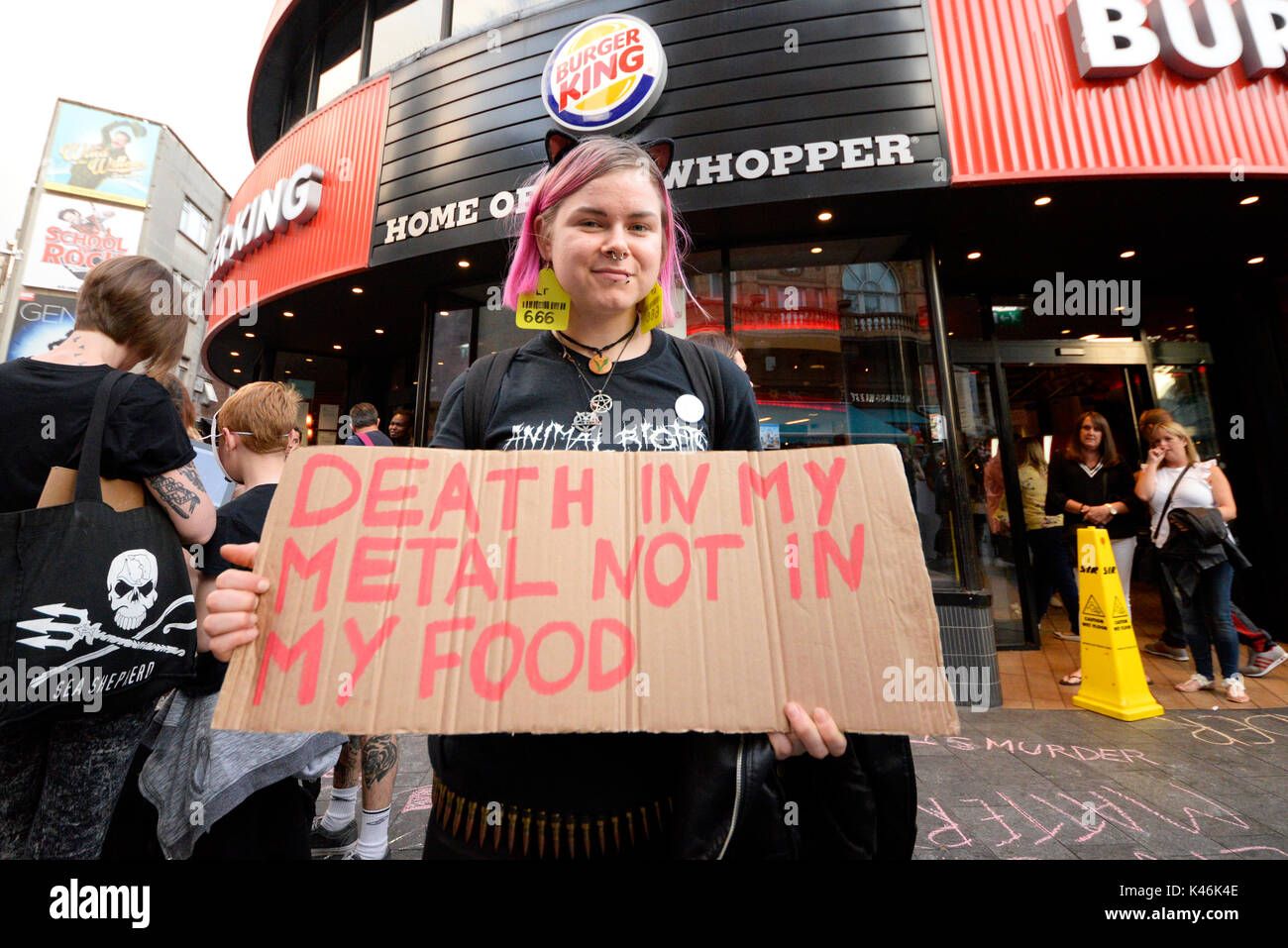 Attivisti per i diritti degli animali che protestavano davanti al Burger King nel quadrato di Leicester, Londra. Riferimento alla morte di metallo la musica. Attivista femmina Foto Stock