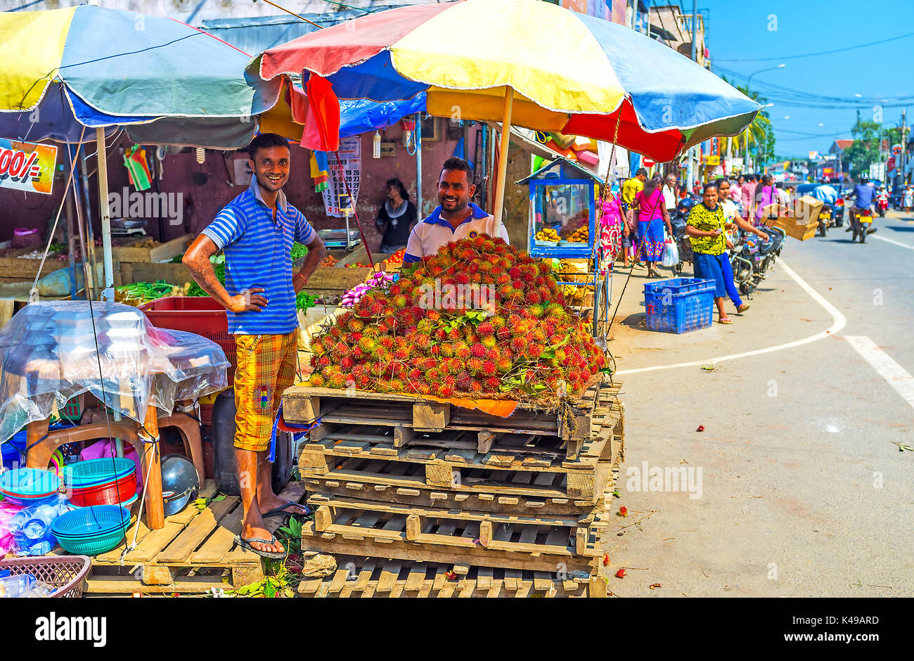 Wellawaya, sri lanka - 2 dicembre 2016: il mercato di venditori offrono maturi frutti tropicali rambutans, il 2 dicembre in wellawaya Foto Stock