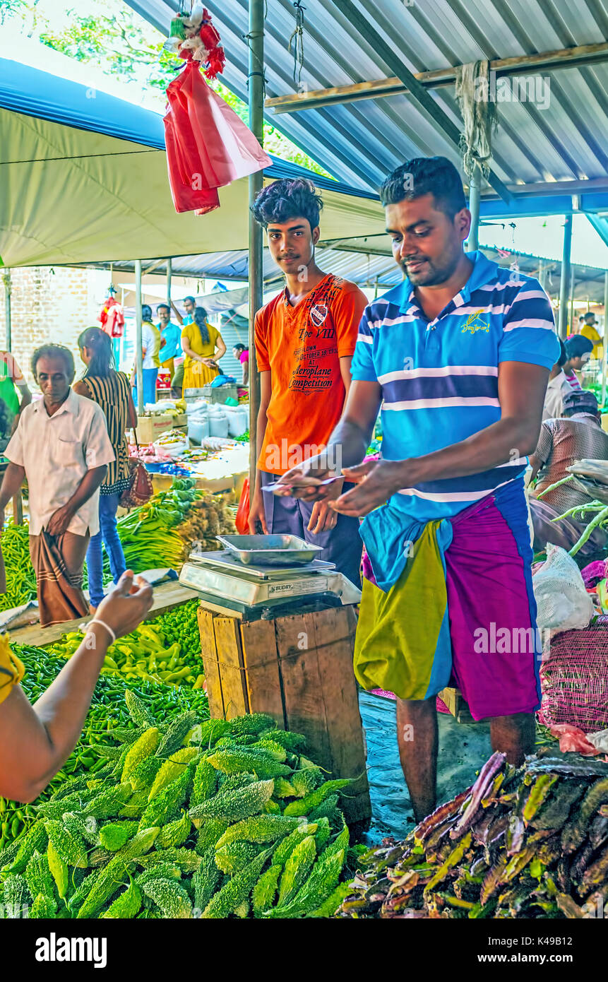 Wellawaya, sri lanka - 2 dicembre 2016: il giovane venditori offrono verdure esotiche nel mercato wellawaya, il 2 dicembre in wellawaya Foto Stock