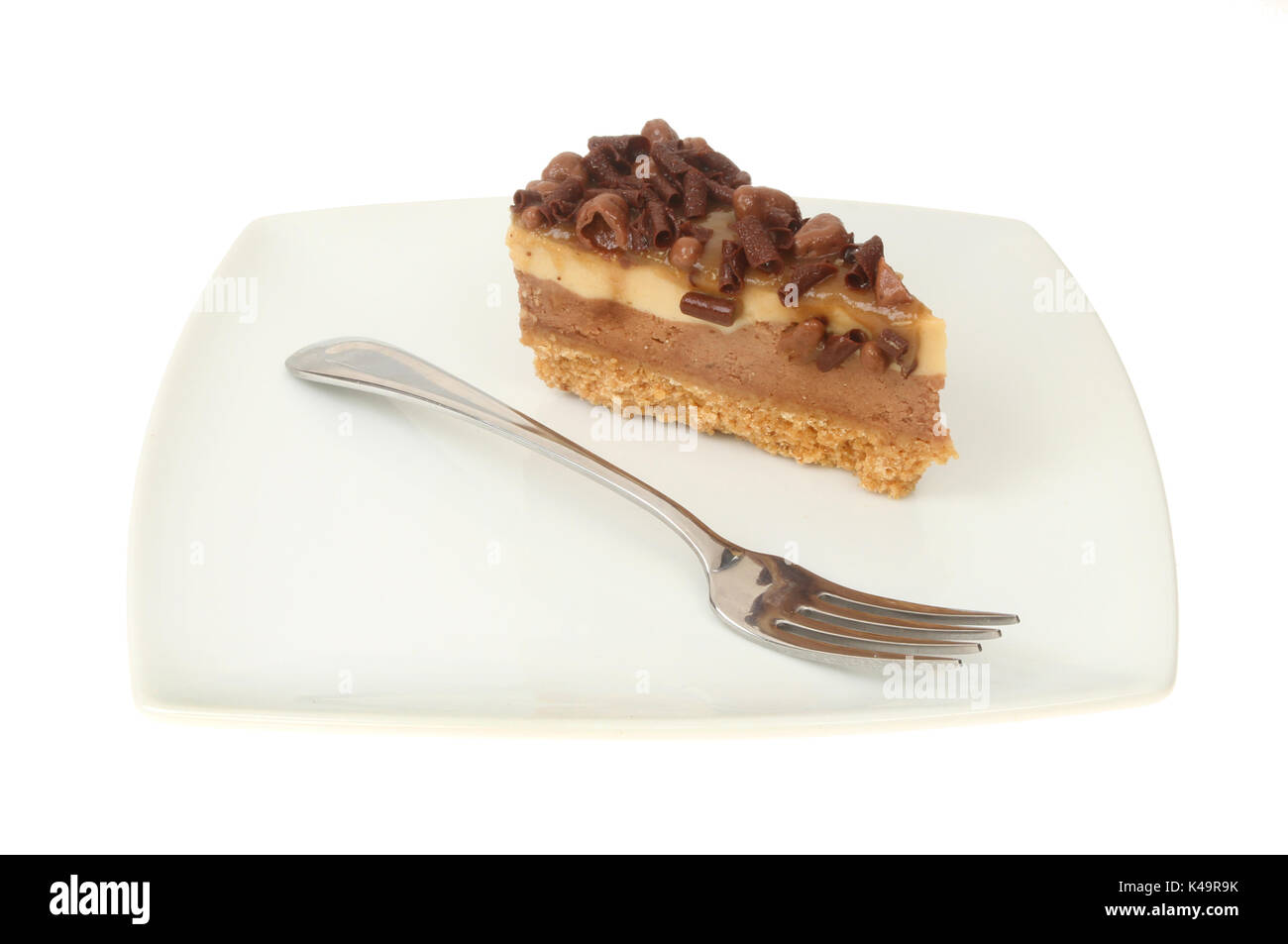 Cioccolato e nido cheesecake su una piastra con una forcella isolata contro bianco Foto Stock