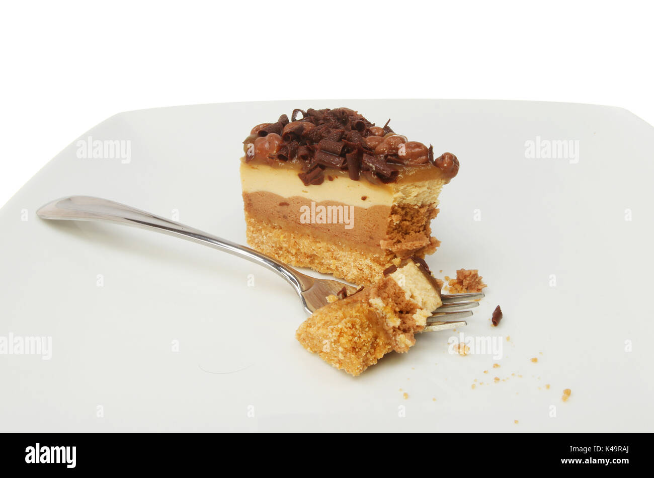 Cheesecake al cioccolato con una forcella su una piastra contro uno sfondo bianco Foto Stock