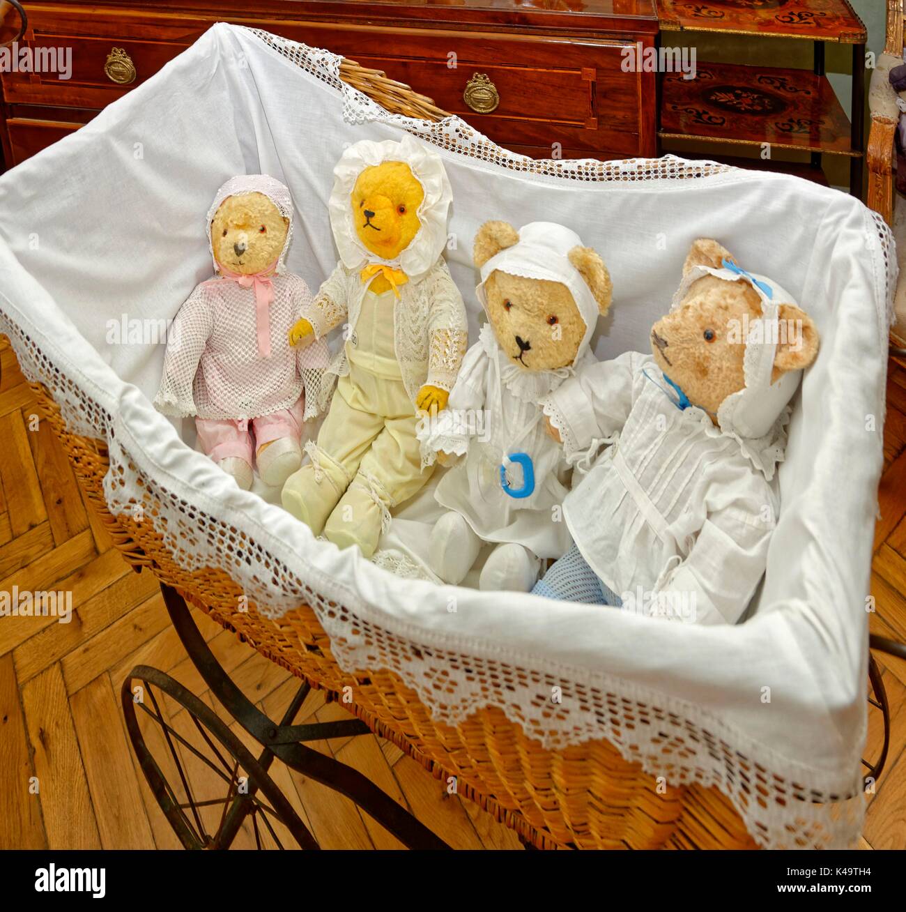 Quattro bambini dell'orso di Teddy in carrozza del bambino del cestino Foto Stock