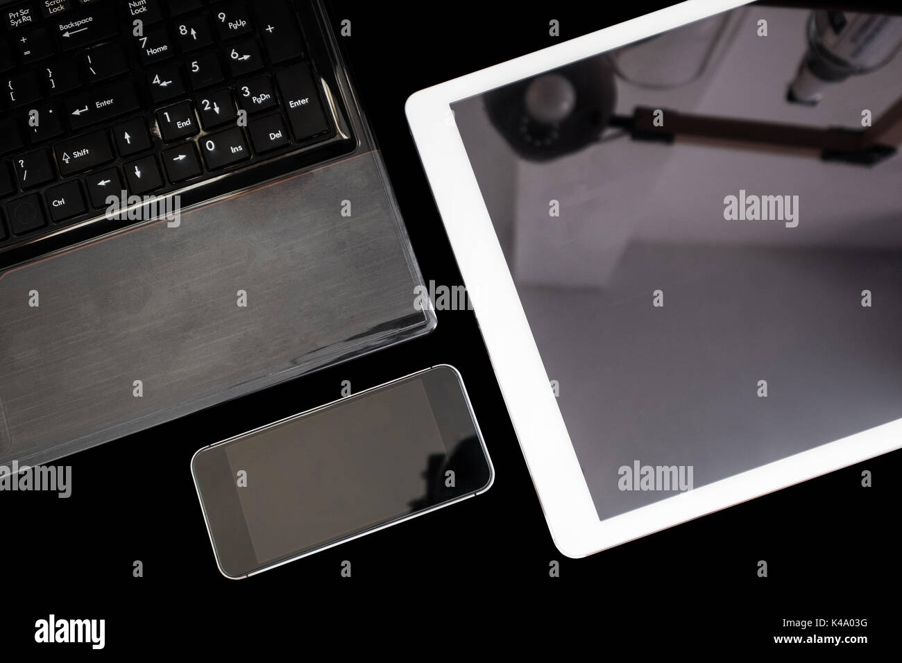 Gruppo di moderni dispositivi elettronici, computer laptop, tavoletta digitale e mobile smart phone,isolati su sfondo nero. Tracciato di ritaglio Foto Stock