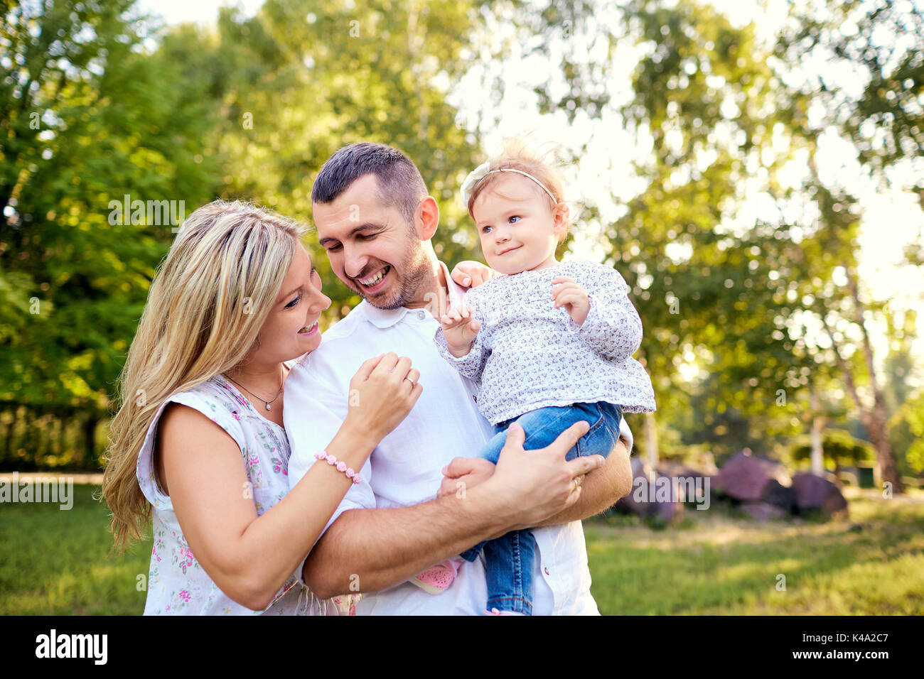 La famiglia felice in un parco in estate autunno. Foto Stock