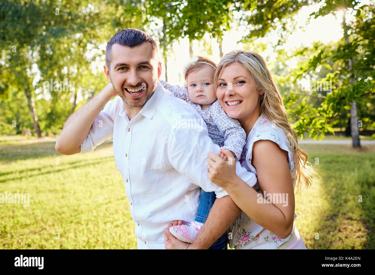 La famiglia felice in un parco in estate autunno. Foto Stock