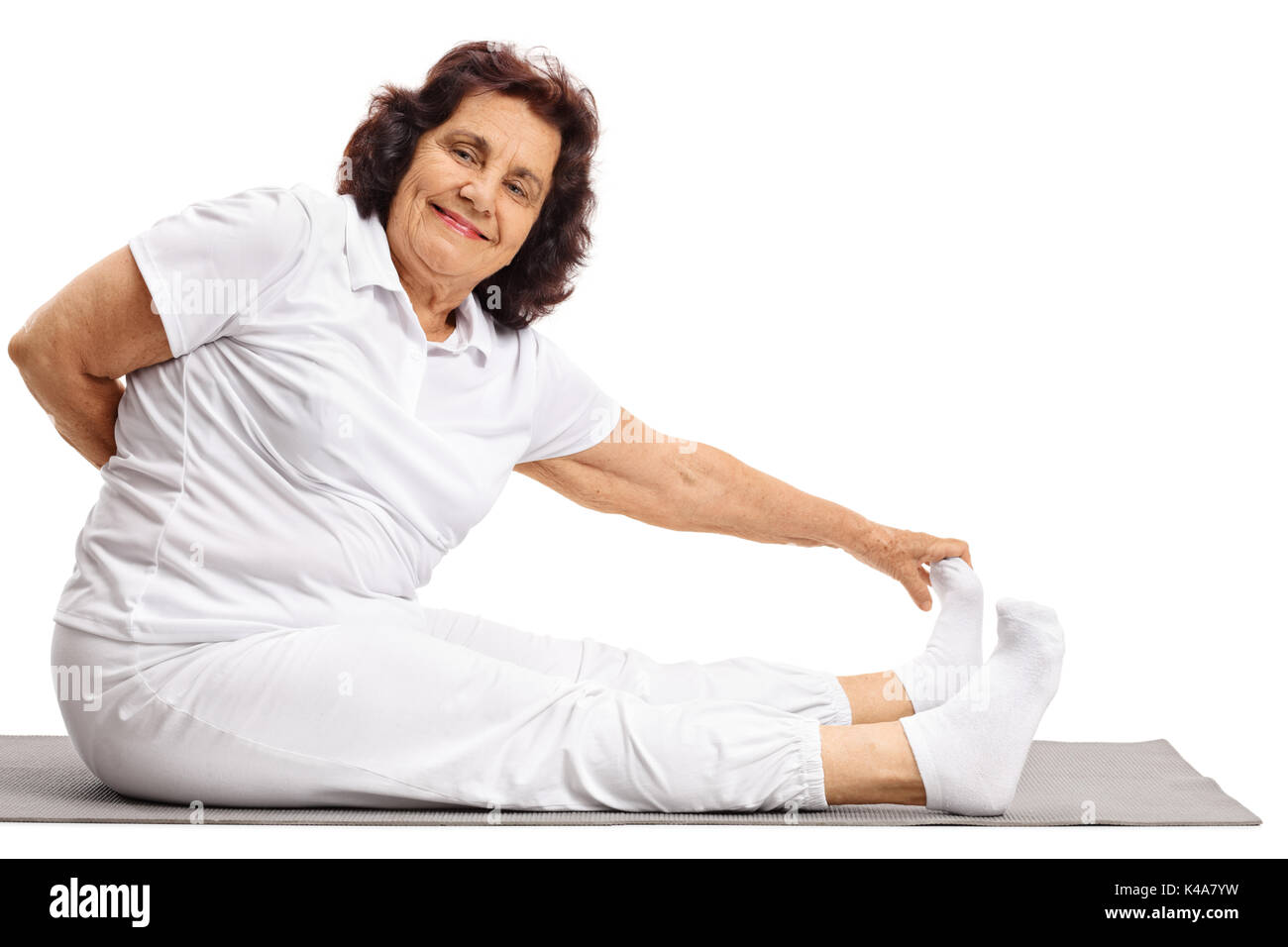 Donna anziana stretching su un esercizio mat isolati su sfondo bianco Foto Stock