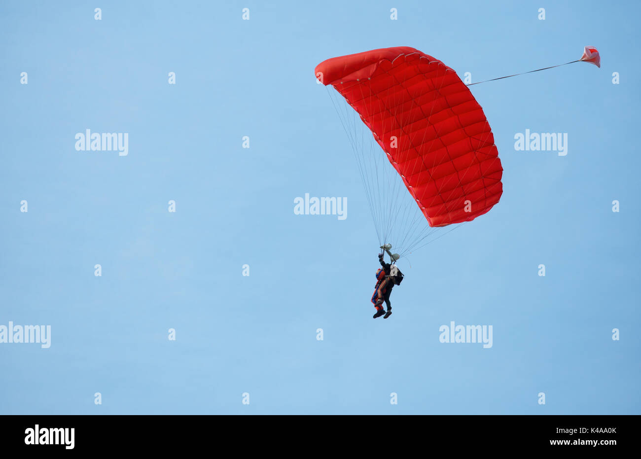 Paracadutista istruttore con pupilla in cielo sotto la cupola rossa. Il concetto di movimento e la libertà. Foto Stock