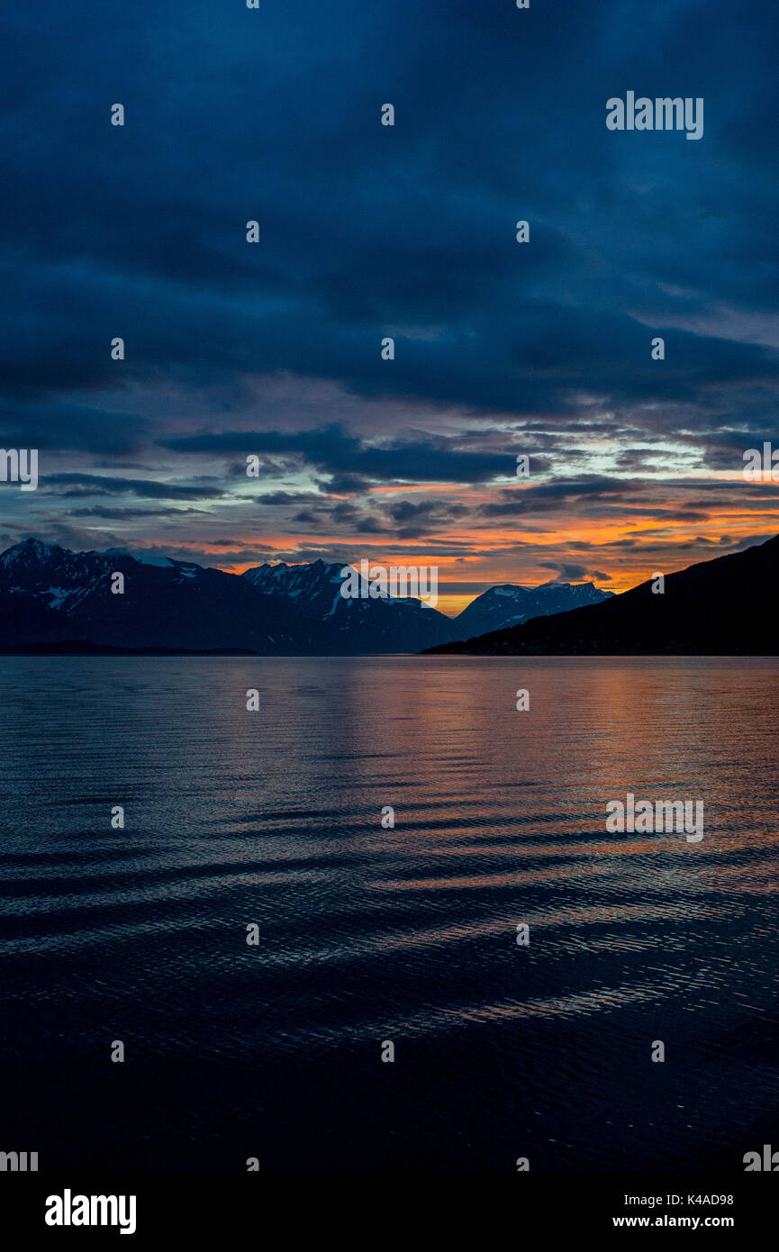 Tramonto riflesso in mare in Lyngenfjord a nord del Circolo Polare Artico, Norvegia durante l'estate. Foto Stock