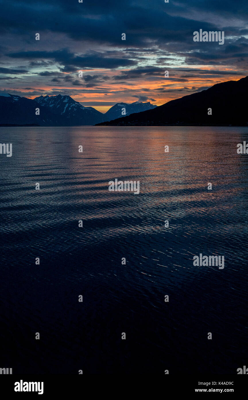 Tramonto riflesso in mare in Lyngenfjord a nord del Circolo Polare Artico, Norvegia durante l'estate. Foto Stock