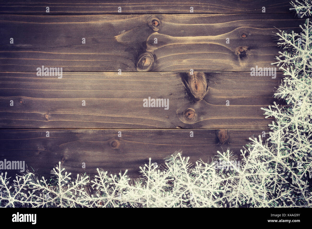 Legno marrone Natale sfondo bianco e i fiocchi di neve con lo spazio. Foto Stock