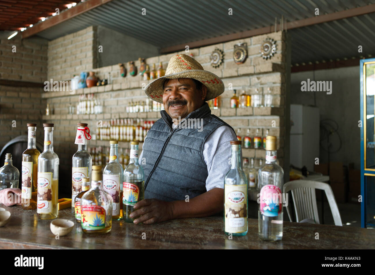 L'uomo, 46 anni, con mescal bottiglie, oaxaca, stato di Oaxaca, Messico Foto Stock