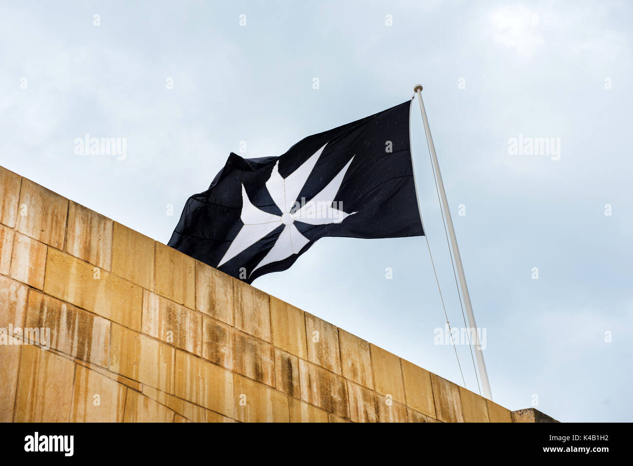 Simbolo dell'Ordine di San Giovanni della croce di malta su una bandiera  nera Foto stock - Alamy
