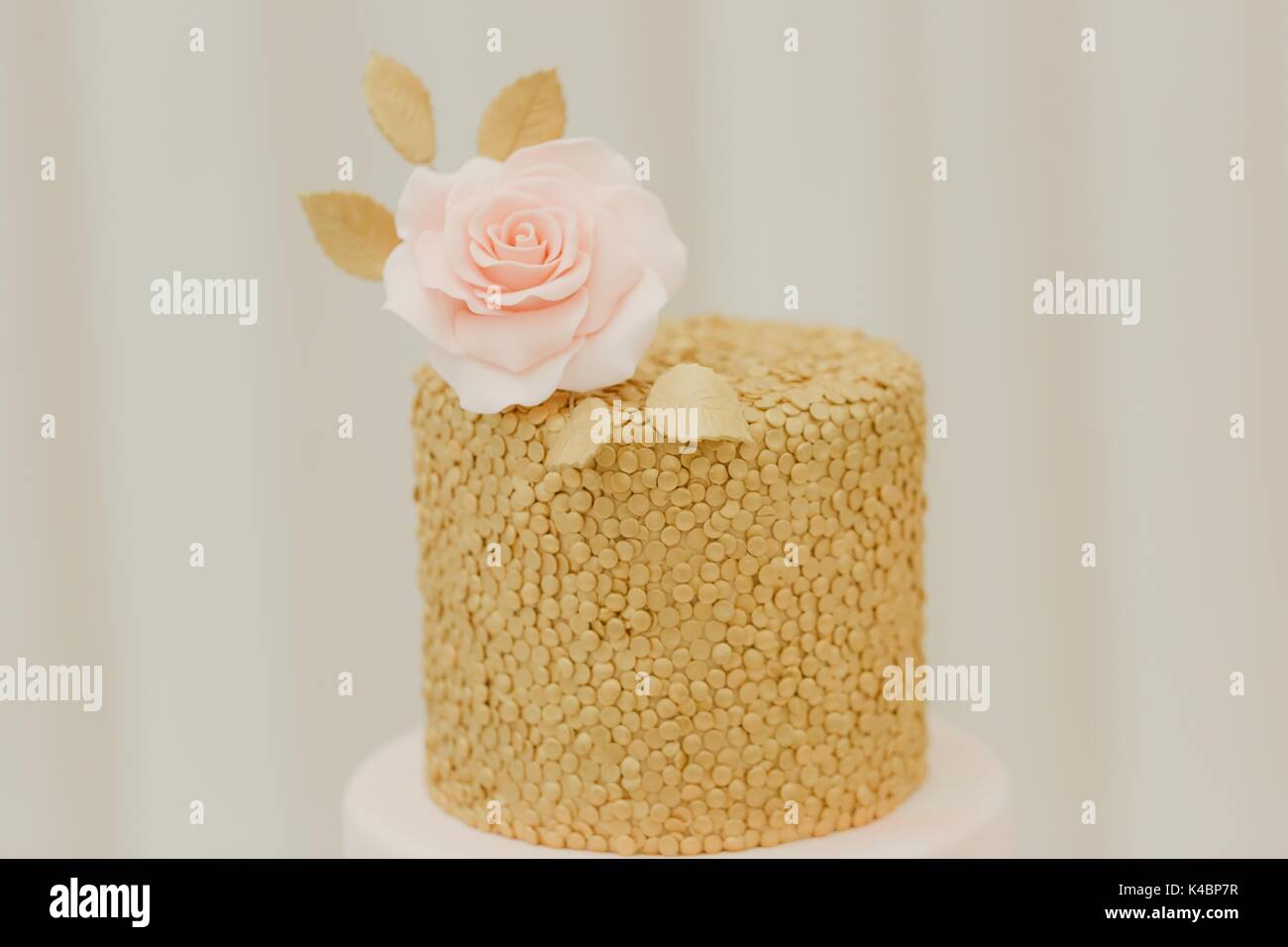Coprimaterasso per torta di nozze a glassa di colore rosa pastello e oro Foto Stock
